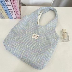 Close-up of textured blue woven fabric on tote bag with stitched branding label