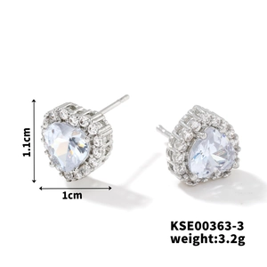 Macro detail of heart-shaped silver stud earrings with diamond halo and product dimensions