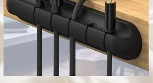Close-up of 4-slot black silicone cable organizer fixed on wood desk with USB wires