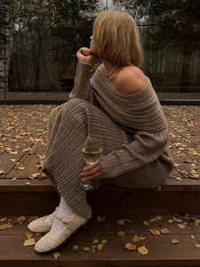 Detail view of brown ribbed knit off-shoulder dress in a scenic autumn outdoor setting