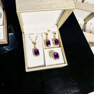 Close-up of gold plated jewelry set with purple gemstones and sparkling crystals