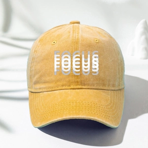 Front view of yellow washed cotton baseball cap with artistic FOCUS letter embroidery