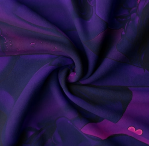 Close-up detail of soft printed fabric with vibrant indigo spiral pattern and pink hearts