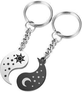 Close-up of stainless steel sun and moon puzzle pendants on keychains for couples