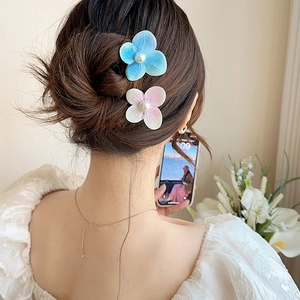 Floral orchid hair clips with pearls in blue and pink, shown on model for summer beach style