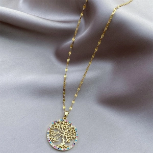 Golden necklace featuring a Tree of Life pendant with colorful zircon stones on grey silk