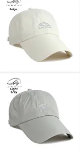 Detail of breathable quick-dry baseball caps with mountain embroidery in beige and light grey
