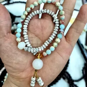 Detailed view of beaded bracelet with natural agate stones and white cloud charm pendant