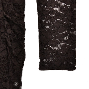 Detailed close-up of dark brown lace fabric featuring intricate floral patterns on sleeves