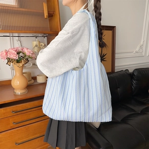 Detail of light blue seersucker striped tote bag showing unique wrinkled texture and capacity