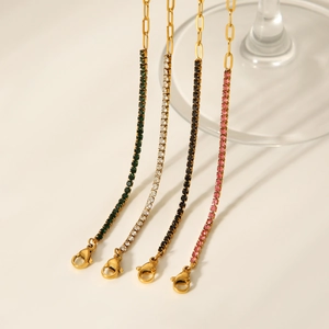 Detailed view of four 18K gold plated zircon bracelets hanging on a glass rim