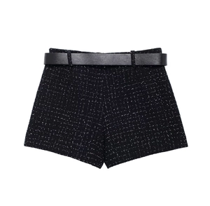 Gros plan d'un short en tweed noir à texture mouchetée blanche avec ceinture en cuir