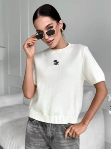 Top in maglia bianca a maniche corte slim fit con girocollo e ricamo sul petto