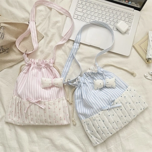 Flat lay of pink and blue striped tote bags with bow detail and drawstring closure