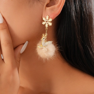 Detail of Christmas reindeer earrings with sparkling rhinestones and soft beige pompom