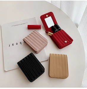 Detail view of mini makeup bag interior with mirror and slots for three lipsticks