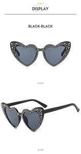 Close-up of heart-shaped sunglasses with rhinestone accents and silver star decorations