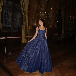 Robe de soirée longue à paillettes bleu marine avec col carré dans un hall luxueux