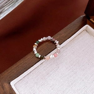 Detailed macro shot of beaded ring with colorful amazonite and pearls on linen cushion