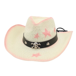 Macro detail of straw cowboy hat with pink stars and metallic skull emblem decoration