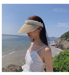 Close-up of handmade straw sun visor with pearl embellishments for summer beach wear
