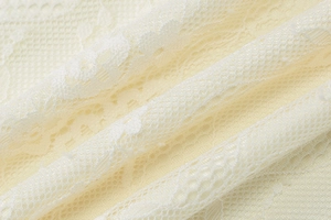 Detailaufnahme von cremefarbenem Spitzenstoff mit feinen Mustern für ein sexy Minikleid