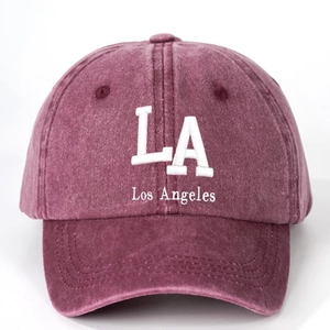 Close-up of white LA Los Angeles 3D embroidery on a vintage washed burgundy cotton baseball cap