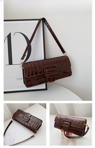 Close-up of brown crocodile embossed faux leather shoulder bag with a large square buckle