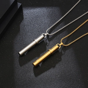 Close-up of functional gold and silver whistle pendants on stainless steel box chains