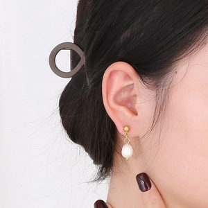 Détail de boucle d'oreille vintage en perle plaqué or 18k porté par un mannequin