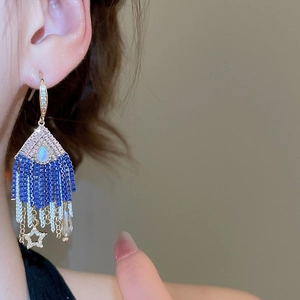 Close-up of blue beaded tassel earrings with star and water drop crystal pendants