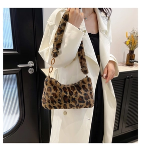 Detail of leopard print faux fur shoulder bag with amber acrylic chain link strap