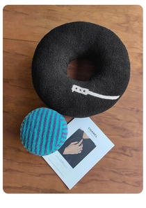 Detailed texture of vinyl record plush pillows on a wooden surface with soft fabric