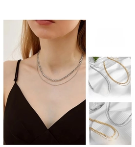 Close-up of gold and silver double-layered Figaro Cuba chain necklaces for women