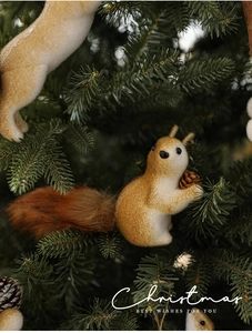 Close-up of realistic squirrel Christmas tree ornament with fluffy tail and pine cone
