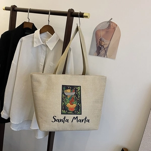 Detail of linen tote bag featuring colorful Santa Marta illustration and ribbon handles
