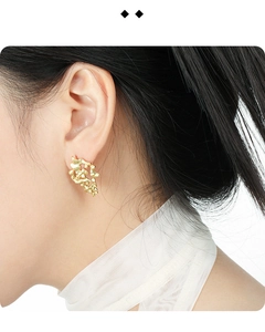 Close-up of model wearing gold hollow irregular earrings with a matte textured design