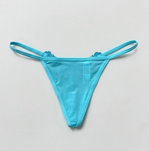 Flat lay of teal lace thong featuring sheer mesh fabric and delicate floral embroidery