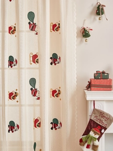 Detail of Christmas lace curtain with Santa embroidery and delicate scalloped edges