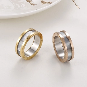 Detail of Roman numeral engravings on gold and rose gold rings with mother-of-pearl inlay