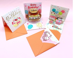 Detailed 3D pop-up birthday cards featuring paper cake and unicorn with orange envelopes