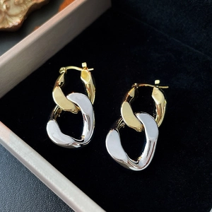 Detail of two-tone gold and silver chain link hoop earrings on black velvet liner