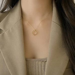 Chic 925 sterling silver geometric pendant necklace in gold on a model in a beige blazer