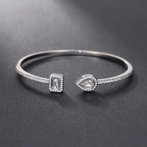 Macro shot of silver open cuff bracelet with zircon rectangular and teardrop gems