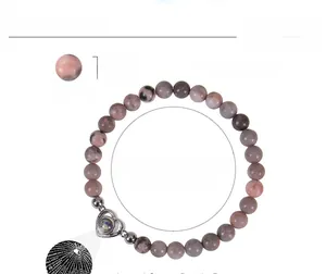 Macro detail of 6mm pink zebra stone beads and heart projection pendant with specifications