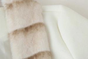 Close-up of elegant faux fur collar detail on a white wool coat showing soft fiber texture
