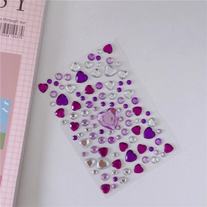 Detail view of purple and clear heart-shaped acrylic gemstone stickers on transparent backing