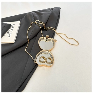 Detail of apple-shaped gold mini chain bag with mirror and jewelry storage inside