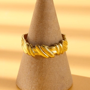Detail showing the golden twisted rope texture on a minimalist irregular stainless steel ring
