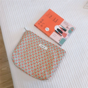 Close-up of floral cotton organizer bag with metal zipper and simple wish label